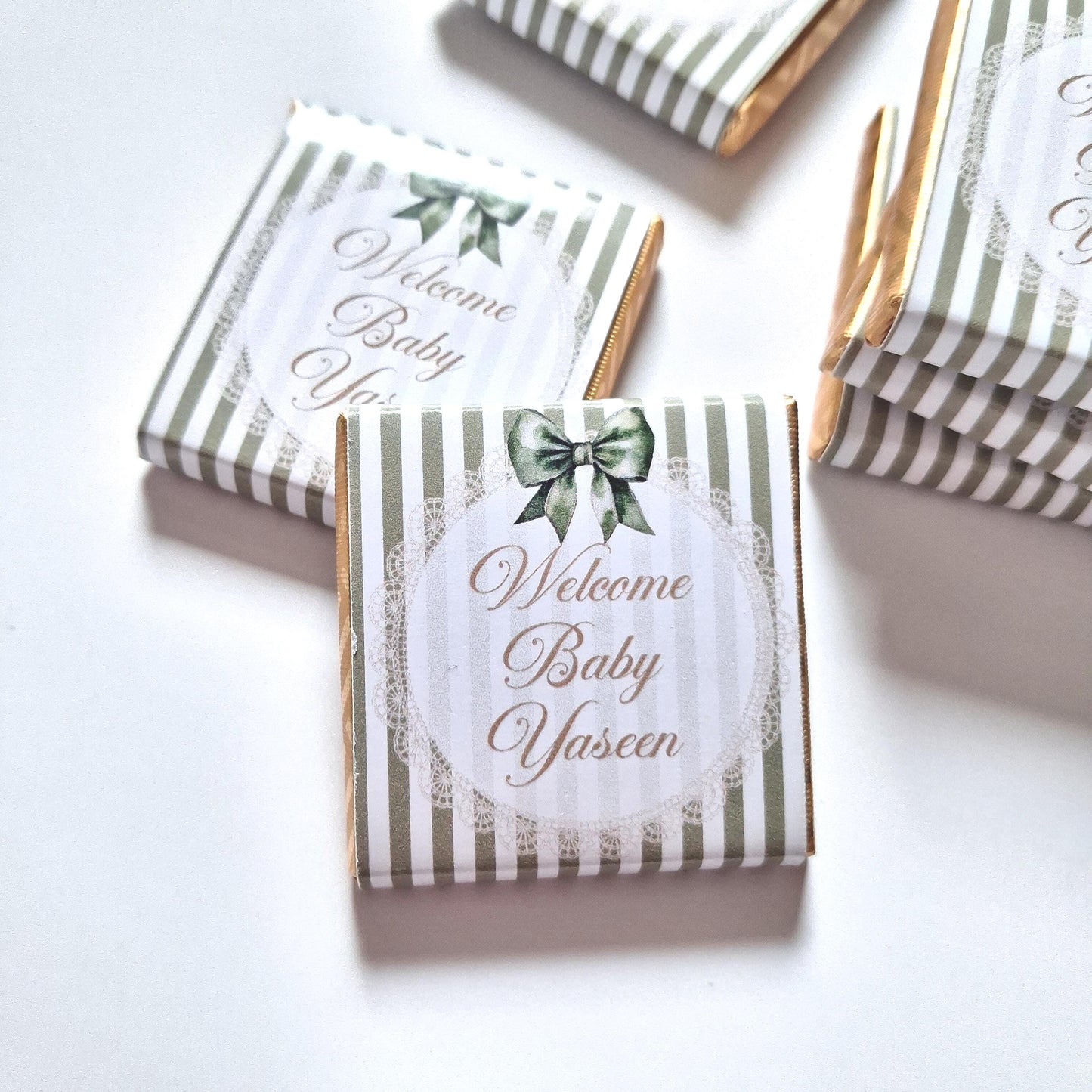 personalised chocolate favours for events like baby showers, christenings, and naming days. Sage green bow with a "Welcome Baby" message.