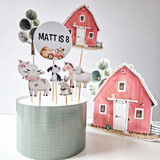 A personalized farmyard cake topper set that includes a red barn and various farm animals.