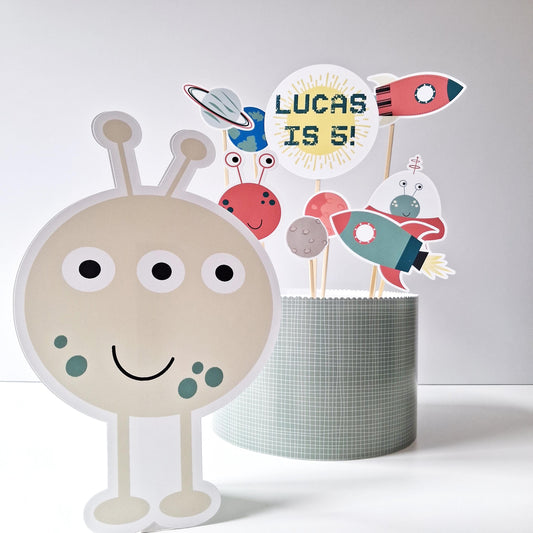 Handmade-in-the-UK cake topper set for birthdays, featuring aliens, rockets, planets, a custom name-and-age topper, and a standing alien figure.