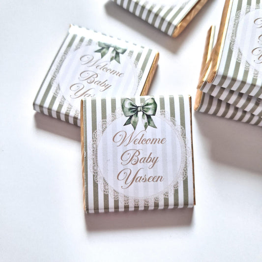 personalised chocolate favours for events like baby showers, christenings, and naming days.  Sage green bow with a "Welcome Baby" message.