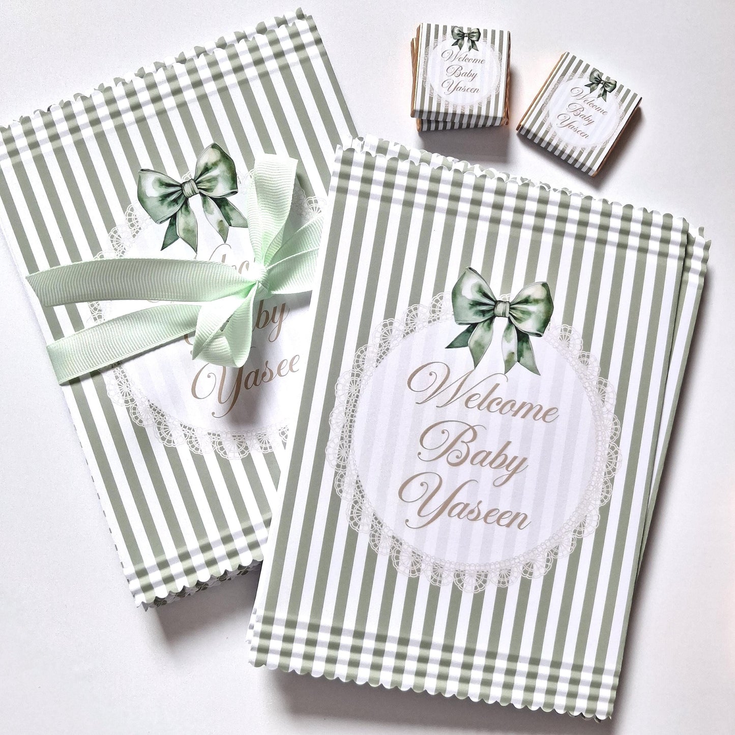 Personalised sage green paper bags with "Welcome Baby" and the baby's name.