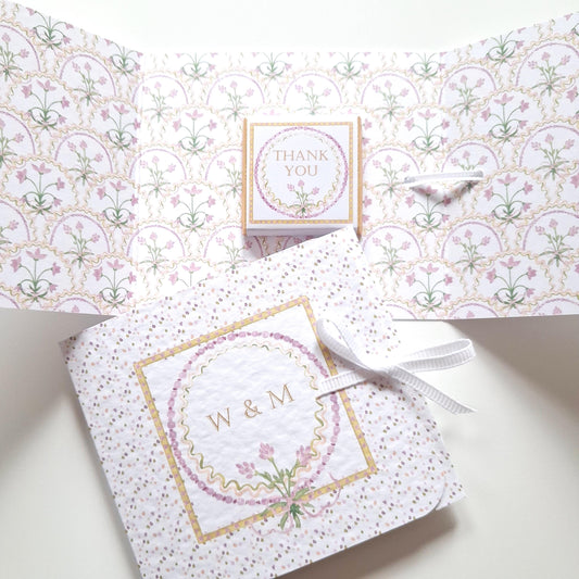 Handmade, ribbon-tied guest gifts with a lilac floral design and chocolate. They are customizable with names or dates, making them ideal for weddings and other special events.